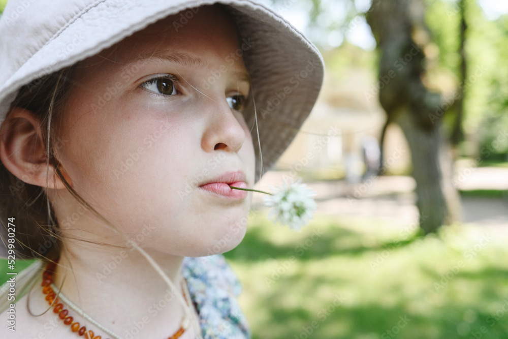 Girl with flower in mouth wearing hat Girl with flower in mouth wearing hat