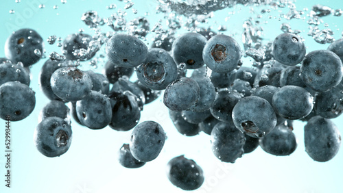 Blueberries pieces falling underwater on blue background. #529984448