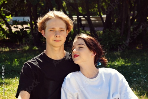 A young couple of teenagers are happy together and want love. First kiss. Girl in a cap