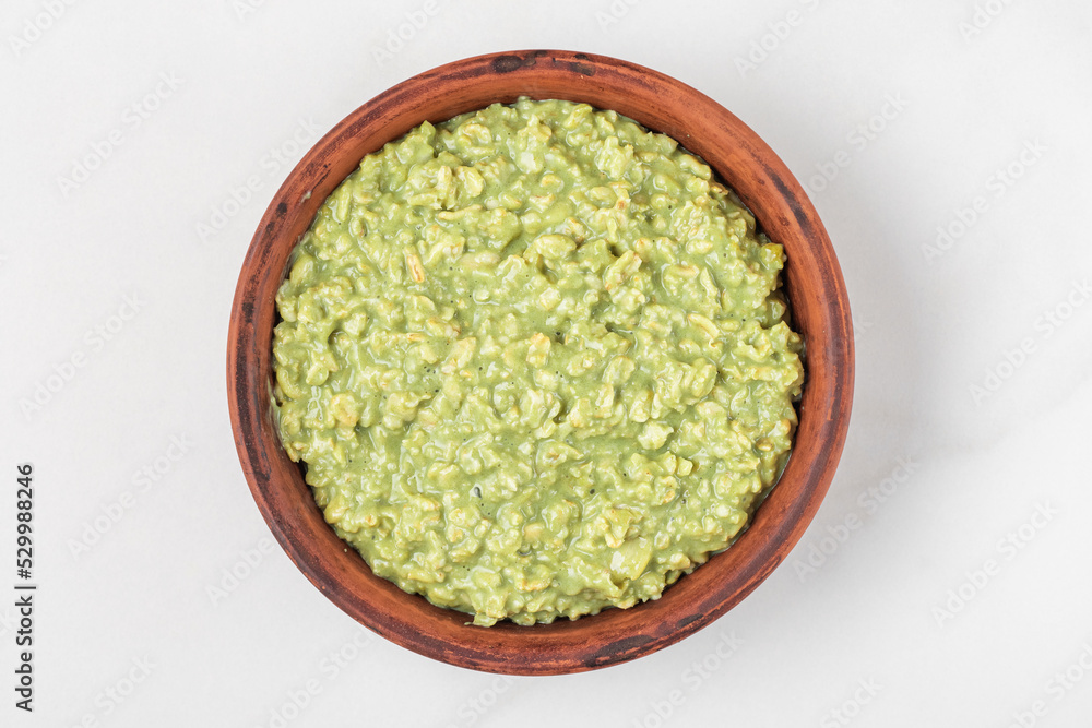 Oatmeal matcha porridge in a bowl on white background. Top view. Healthy breakfast Oatmeal matcha porridge in a bowl on white background. Top view. Healthy breakfast