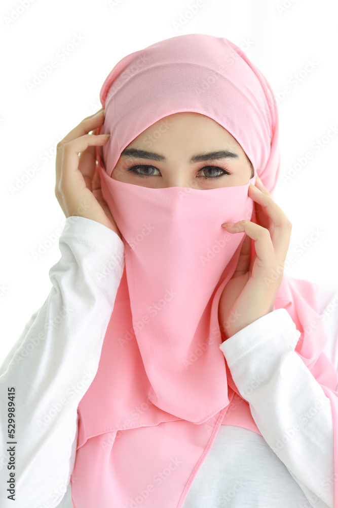 Pretty young asian Arabian woman wearing muslim pink hijab confident in  studio. Isolated white background portrait with beautiful eyes girl. She  touching her face. Advertisement portrait concept. Photos | Adobe Stock