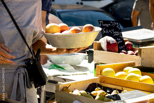 Fotografia Femme avec un plateau de fruits dans le marché alimentaire sur les quais de Saôn