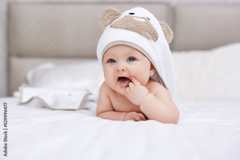 adorable baby girl lies on a white bed with a towel adorable baby girl lies on a white bed with a towel