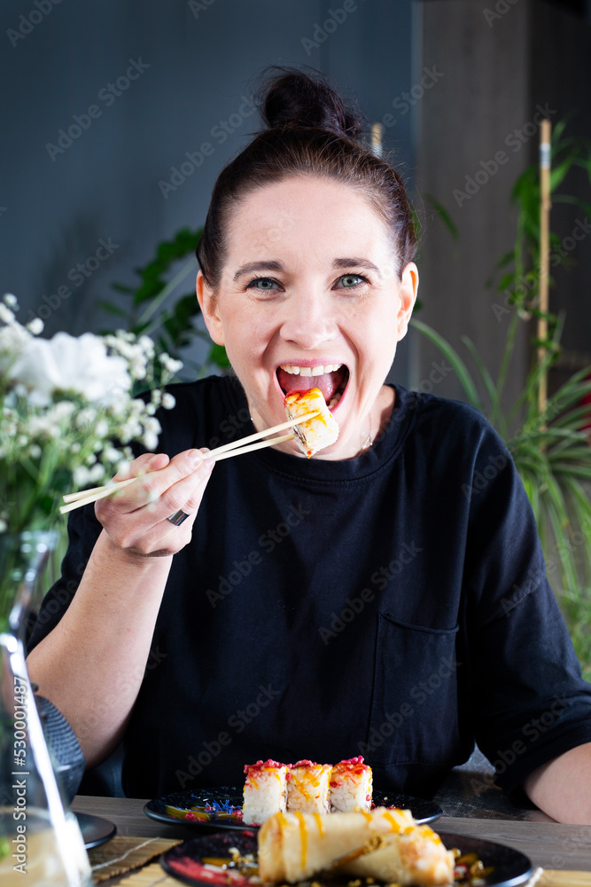 Woman eating sushi.
A young woman is eating sushi lunch at a Japanese restaurant Woman eating sushi.
A young woman is eating sushi lunch at a Japanese restaurant
