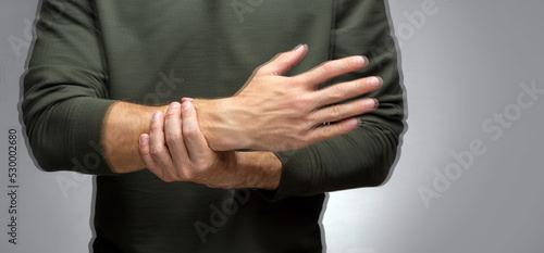 a man with a tremor tries to keep his hand from trembling with t