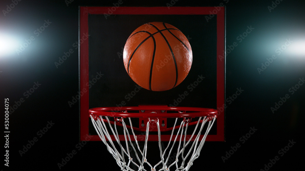 Detail of basketball ball hitting the basket.