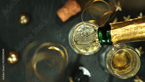 Champagne pouring in a glass from a bottle, top view. #530004044