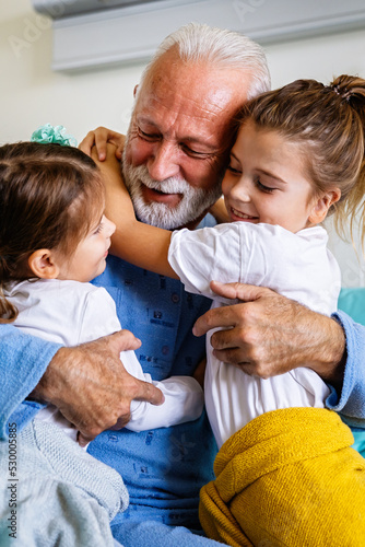 Φωτογραφία Happy laughing grandfather playing, having fun with his grandchildren together