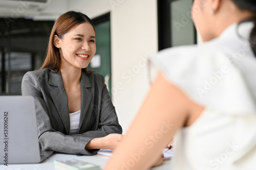 Foto Asian female business consultant or insurance agent meets with her female client