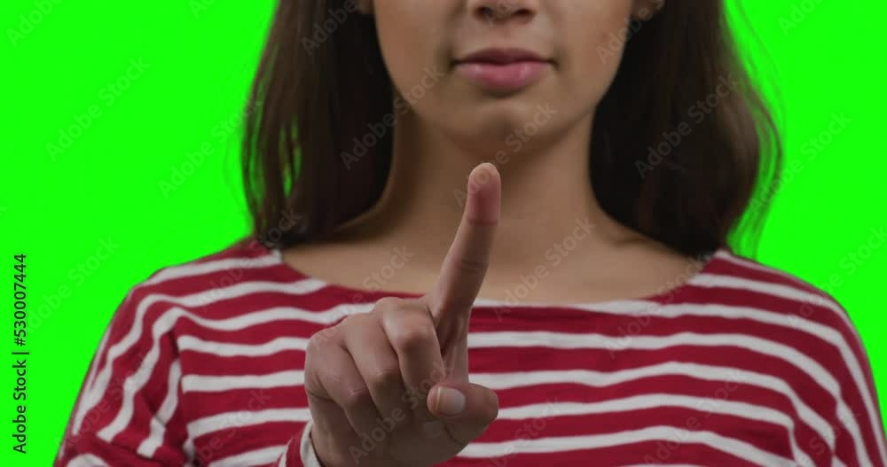 Caucasian woman pointing on green background Caucasian woman pointing on green background