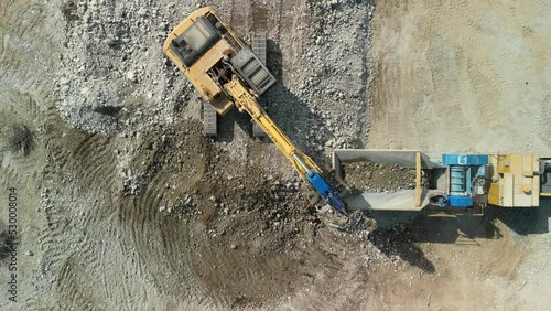 Construction excavator works at the industrial quarry that loads earth, sand and stones. photo