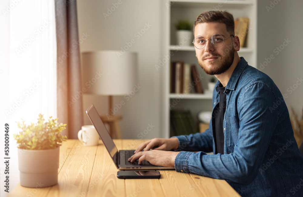 Portrait of bearded man freelancer working on laptop from home, coding remotely work Portrait of bearded man freelancer working on laptop from home, coding remotely work