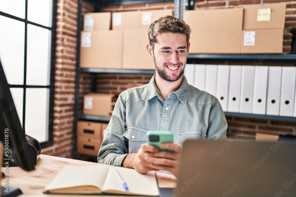 Young man ecommerce business worker using laptop and smartphone at office