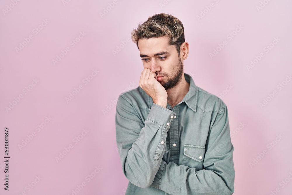 Hispanic man with beard standing over pink background thinking looking tired and bored with depression problems with crossed arms. Hispanic man with beard standing over pink background thinking looking tired and bored with depression problems with crossed arms.