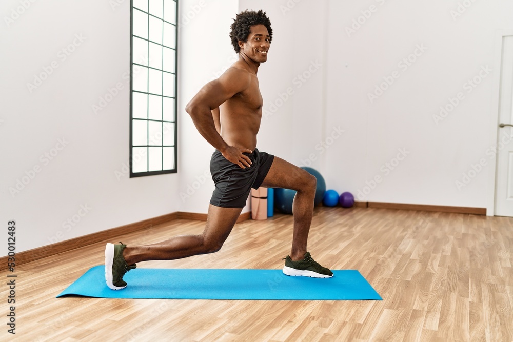 Young african american man training legs exercise at gym