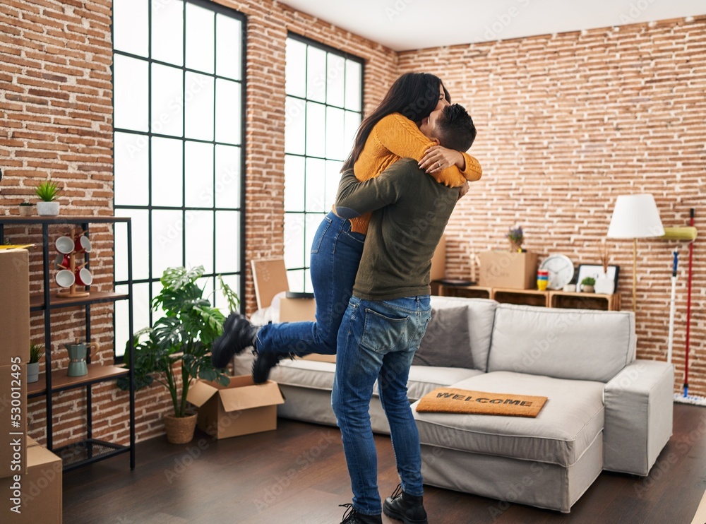 Man and woman couple hugging each other standing at new home