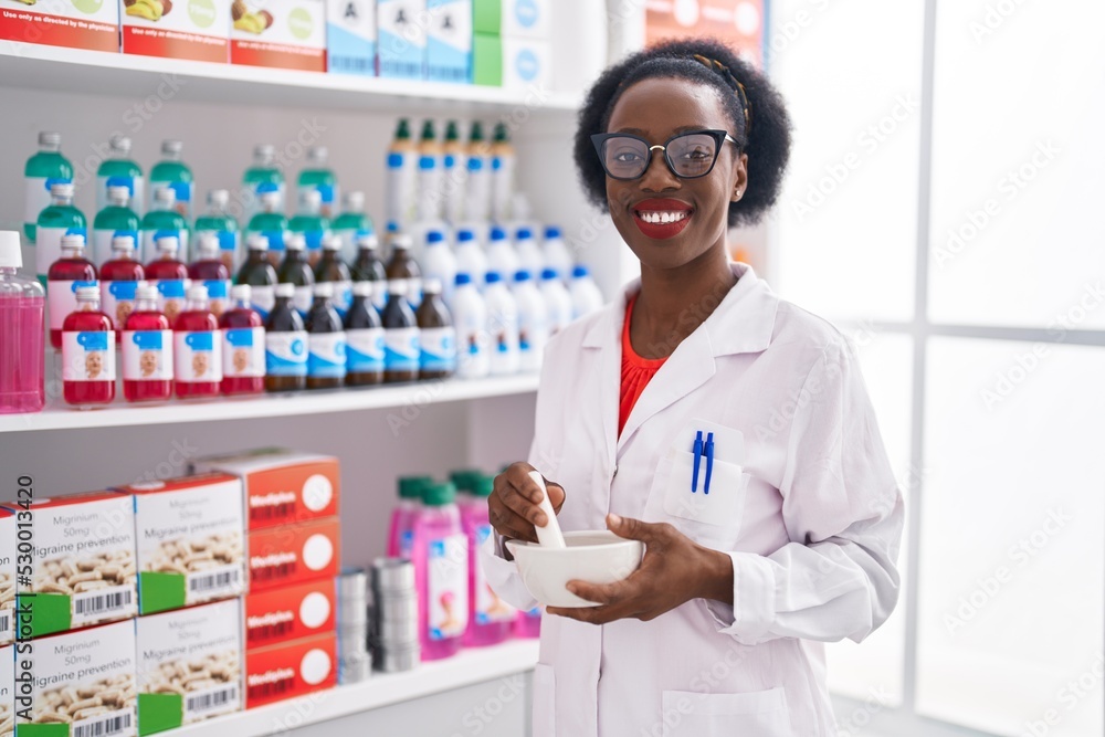 African american woman pharmacist smiling confident working at pharmacy
