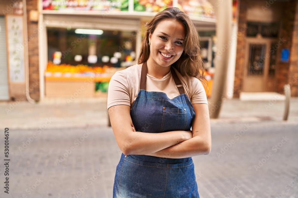 Young beautiful hispanic woman waitress smiling confident standing with arms crossed gesture at fruit store Young beautiful hispanic woman waitress smiling confident standing with arms crossed gesture at fruit store