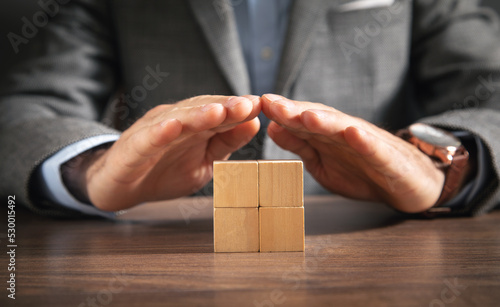 Businessman showing wooden empty cubes.