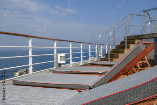 View from open outdoor deck of legendary luxury ocean liner cruise ship on passage during Transatlantic Crossing from Southampton to New York with deck chairs, railing and superstructure © Tamme