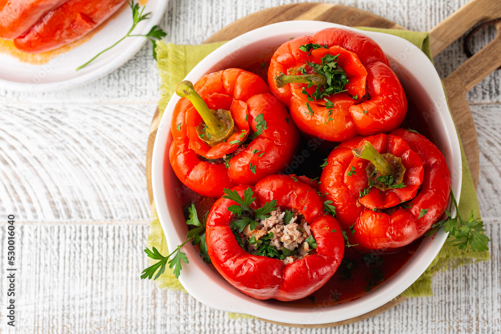 Top view of Red bell peppers stuffed with minced meat and rice and cooked in a tomato sauce. Top view of Red bell peppers stuffed with minced meat and rice and cooked in a tomato sauce.