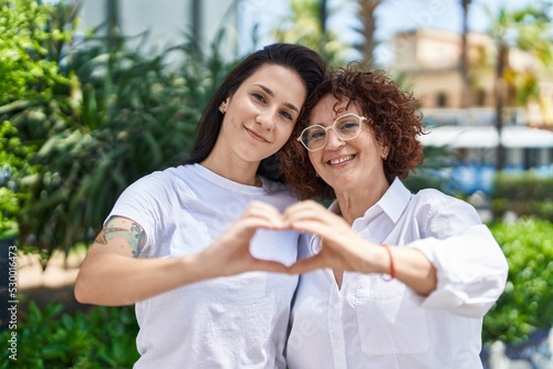 Two women mother and daughter doing heart gesture with hands at park © Krakenimages.com