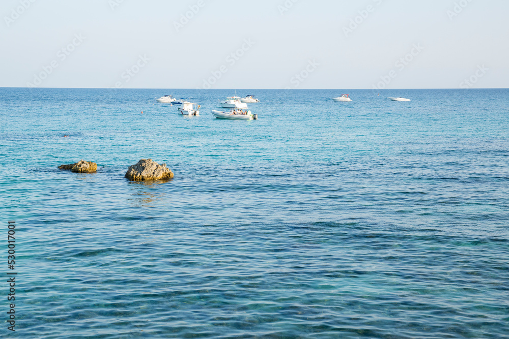 Seascape with boats anchored offshore in a sunny day. Sicily, Italy.