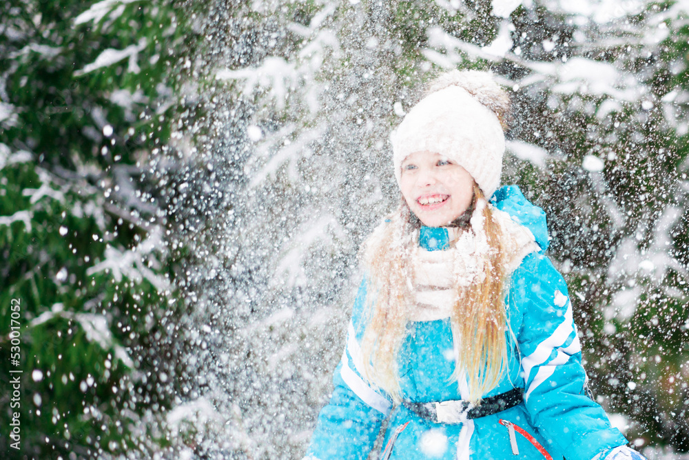 A cute little girl in white hat throws up the snow. A cute little girl in white hat throws up the snow.
