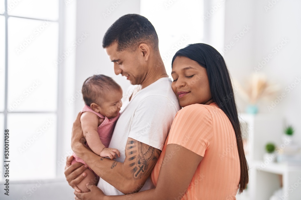 Hispanic family hugging each other standing at home Hispanic family hugging each other standing at home