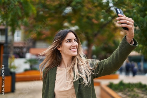 Young woman smiling confident making selfie by the smartphone at park