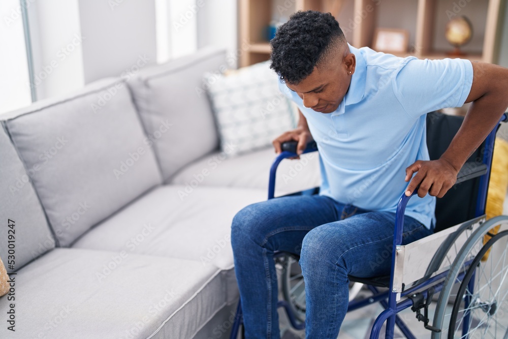 Young latin man sitting on wheelchair at home