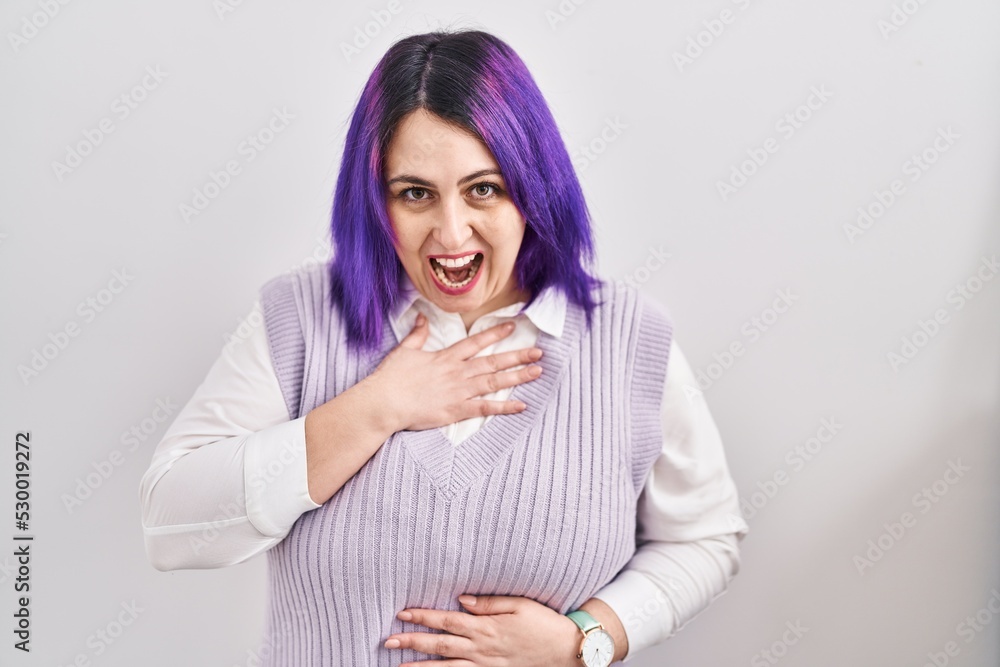 Plus size woman wit purple hair standing over white background smiling and laughing hard out loud because funny crazy joke with hands on body. Plus size woman wit purple hair standing over white background smiling and laughing hard out loud because funny crazy joke with hands on body.
