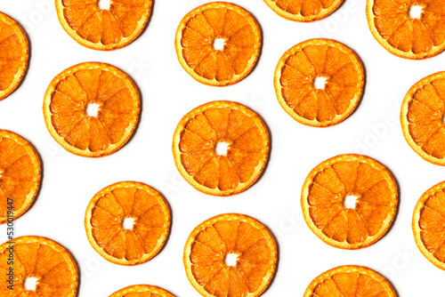 Flat lay pattern of dry orange slices isolated on white background. Top view