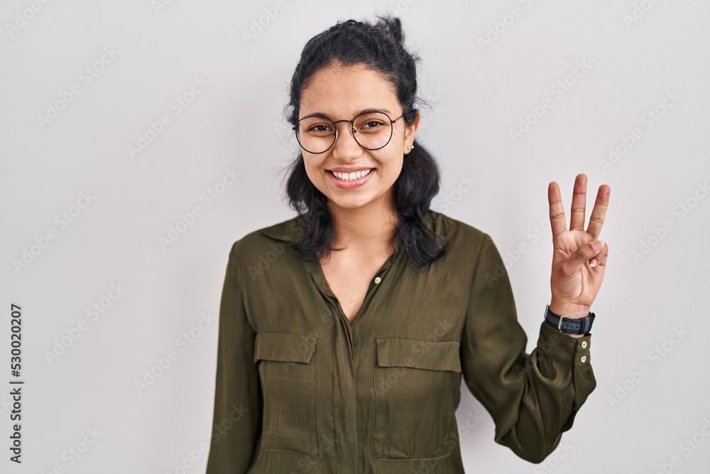 Hispanic woman with dark hair standing over isolated background showing and pointing up with fingers number three while smiling confident and happy. Hispanic woman with dark hair standing over isolated background showing and pointing up with fingers number three while smiling confident and happy.