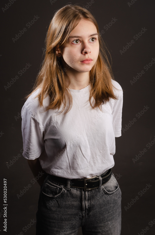 portrait of a girl in a white T-shirt on a dark background portrait of a girl in a white T-shirt on a dark background