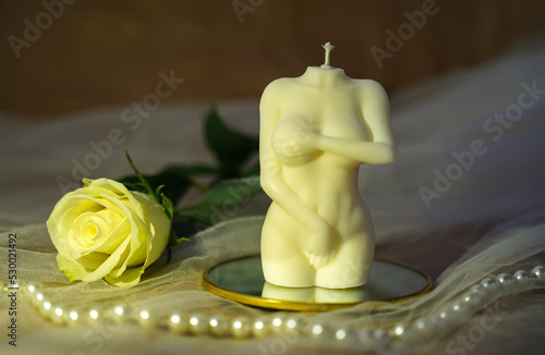 Candle and rose flower. Nude figure of female body. Concept of intimacy, sex, women health