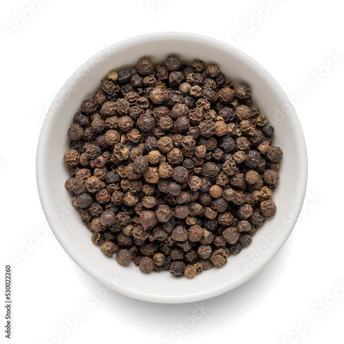 Black pepper in white bowl isolated on white. Top view. photo