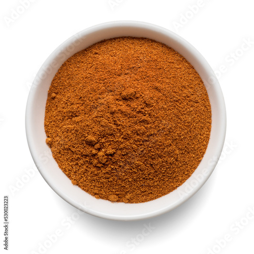 Ground paprika powder in round bowl isolated on white. Top view.