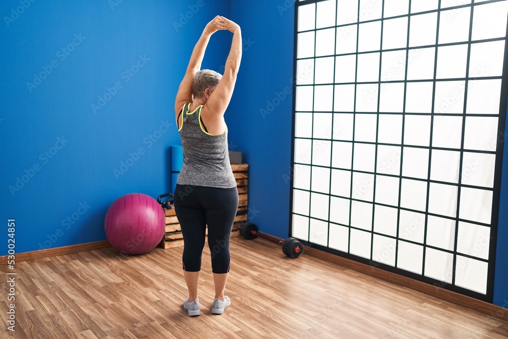 Middle age woman stretching at sport center