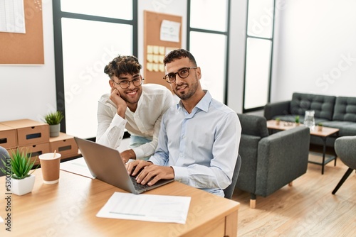 Two hispanic men business workers smiling confident working at office