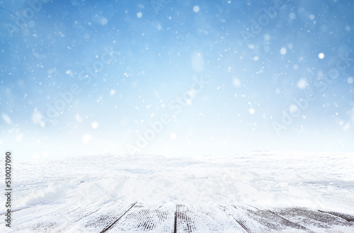 defocused winter background with snowfall and snow covered empty wooden walkways © Ирина Гутыряк