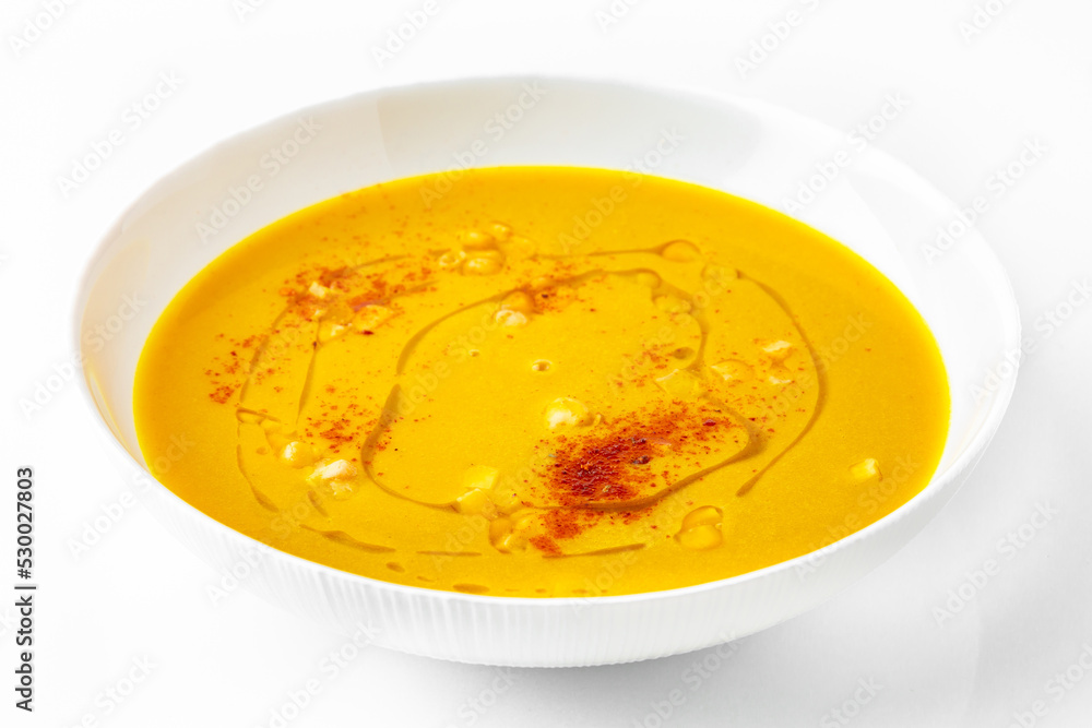 Fragrant first course from corn and paprika. Vegetarian dietary cream soup based on baked and fresh vegetables with herbs. Fitness menu. Delivery of prepared food. White background Fragrant first course from corn and paprika. Vegetarian dietary cream soup based on baked and fresh vegetables with herbs. Fitness menu. Delivery of prepared food. White background