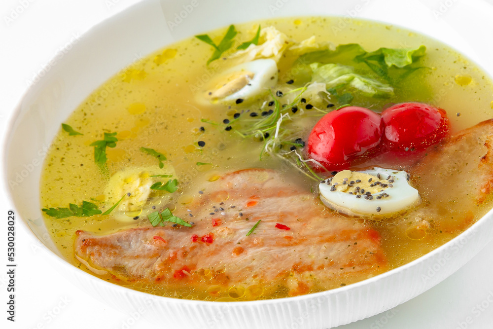 Fragrant first coursefrom chicken broth, quail eggs and poultry meat. Dietary cream soup based on baked and fresh vegetables with herbs. Fitness menu. Delivery of prepared food. White backgr Fragrant first coursefrom chicken broth, quail eggs and poultry meat. Dietary cream soup based on baked and fresh vegetables with herbs. Fitness menu. Delivery of prepared food. White backgr