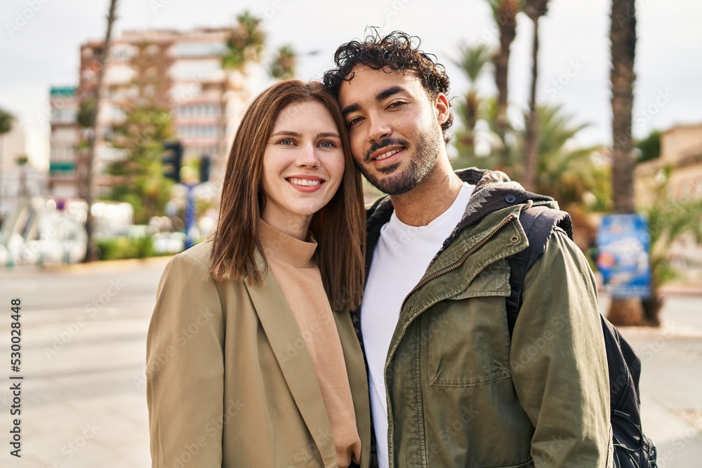 Man and woman smiling confident hugging each other at street