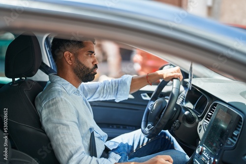 Young arab man stressed driving car at street © Krakenimages.com