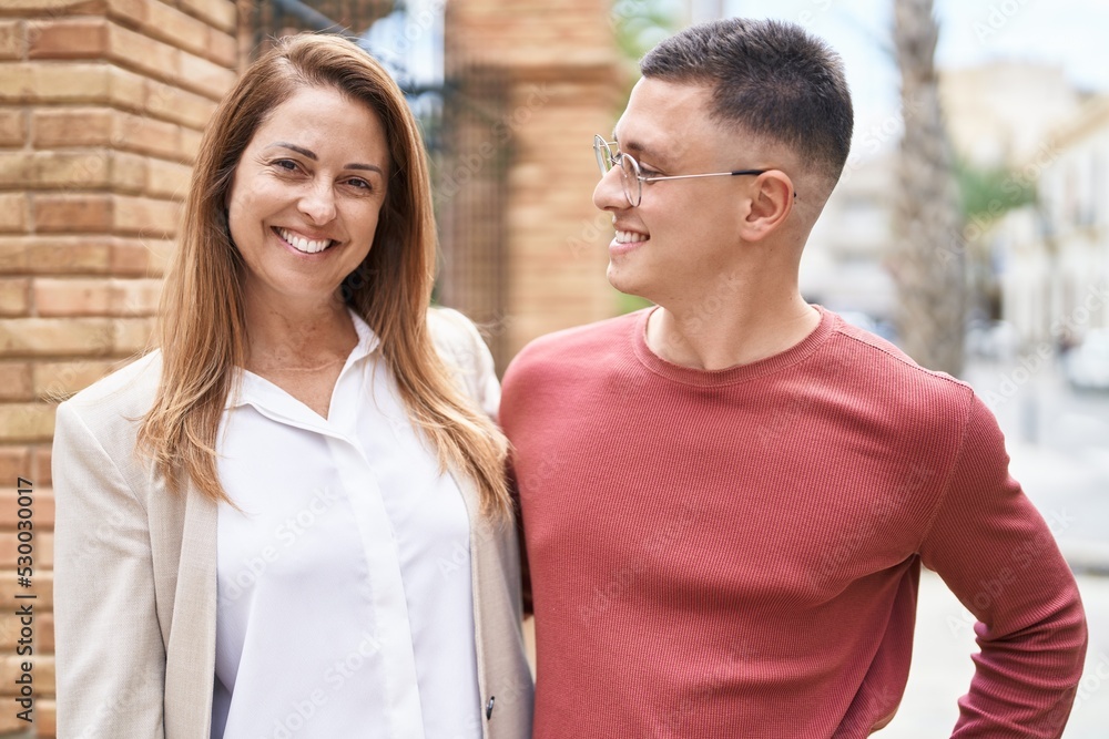 Man and woman mother and son hugging each other at street