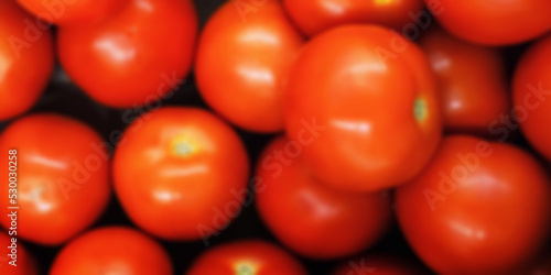 Defocused red fresh tomato harvest background view from above. Agriculture concept.