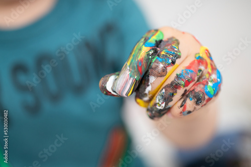 close up of a child's hand covered in paint, hand painting