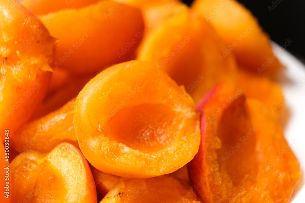 Juicy apricot slices on a black background, side view. Juicy apricot slices on a black background, side view.