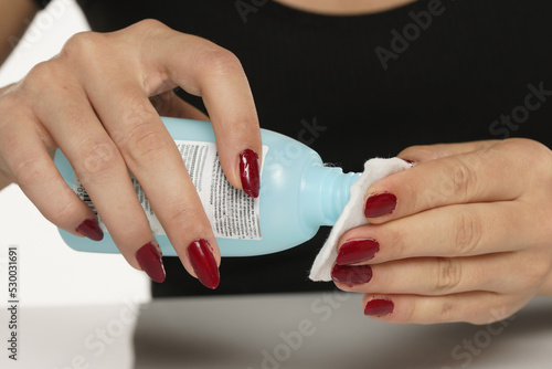 Woman applying acetone on cotton pad photo